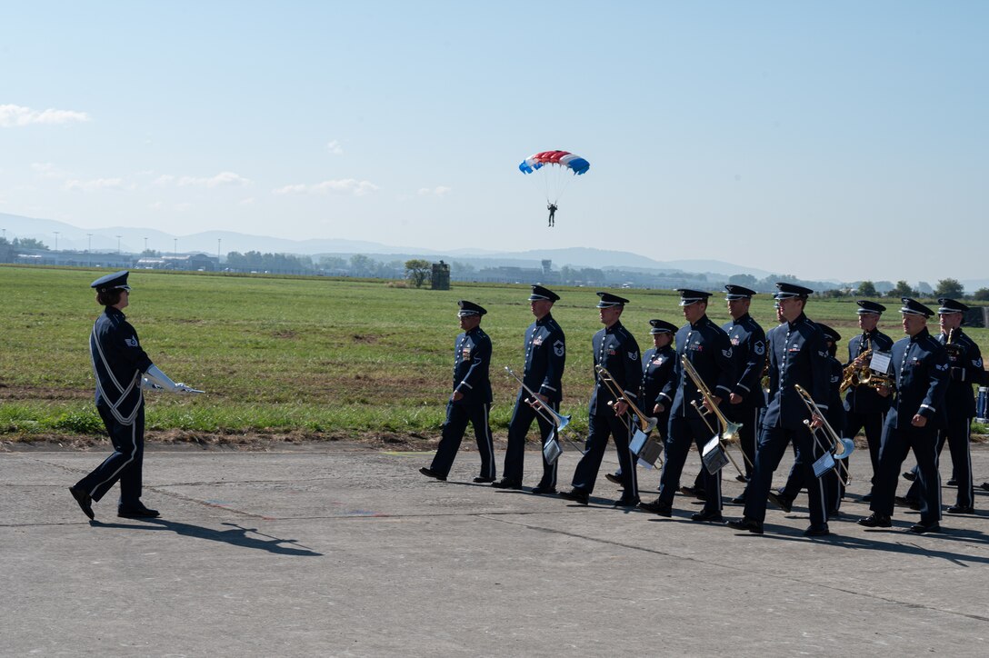 U.S. Air Force Airmen assigned to the U.S. Air Forces in Europe Ceremonial Band, march during the opening ceremony of the NATO Days event at Leoš Janáček Airport in Ostrava, Czech Republic, Sept. 16, 2023. Polish special forces servicemembers parachuted behind the band with the flags of various NATO countries during the opening ceremony. (U.S. Air Force photo by Airman 1st Class Christopher Campbell)