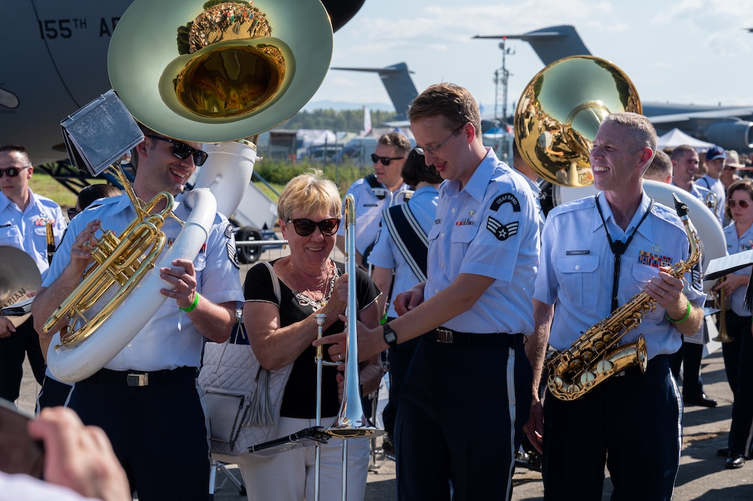 U.S. Air Force Airmen assigned to the U.S. Air Forces in Europe Ceremonial Band, prepare for a photo with a Czech woman after their performance during the NATO Days event at Leoš Janáček Airport in Ostrava, Czech Republic, Sept. 16, 2023.