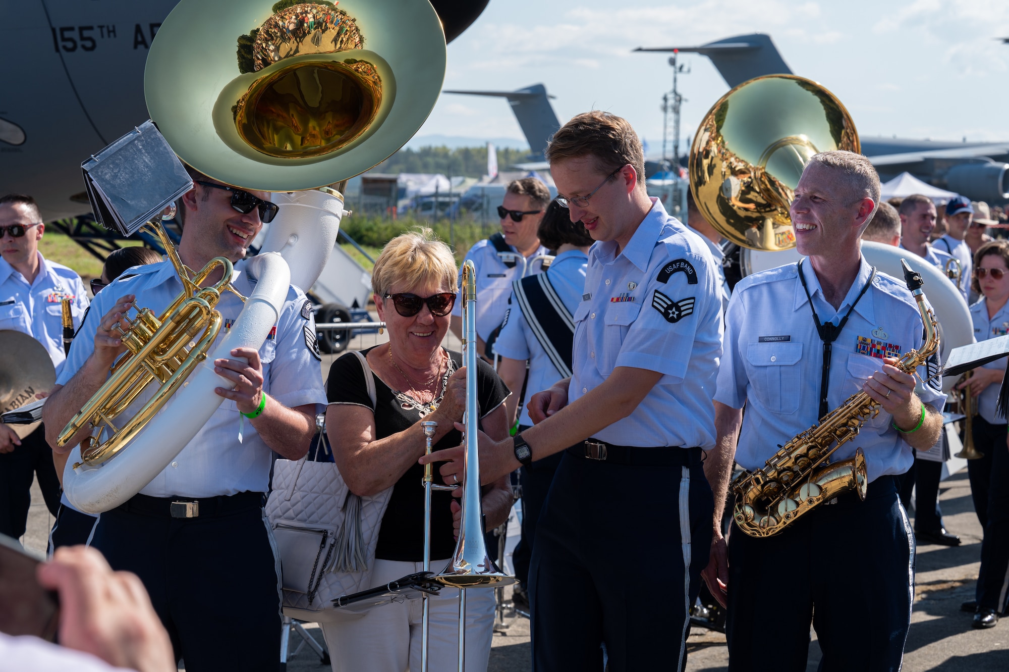 U.S. Air Force Airmen assigned to the U.S. Air Forces in Europe Ceremonial Band, prepare for a photo with a Czech woman after their performance during the NATO Days event at Leoš Janáček Airport in Ostrava, Czech Republic, Sept. 16, 2023.