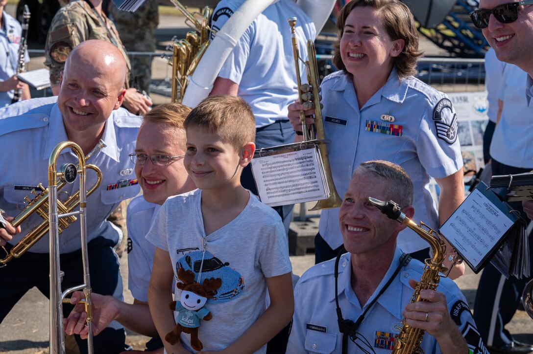 U.S. Air Force Airmen assigned to the U.S. Air Forces in Europe Ceremonial Band, pose for a photo with a Czech boy after their performance during the NATO Days event at Leoš Janáček Airport in Ostrava, Czech Republic, Sept. 16, 2023. The USAFE Band serves as a bridge to increase cultural ties and enrich the partnerships between the U.S. and Czech Republic through music. (U.S. Air Force photo by Airman 1st Class Christopher Campbell)