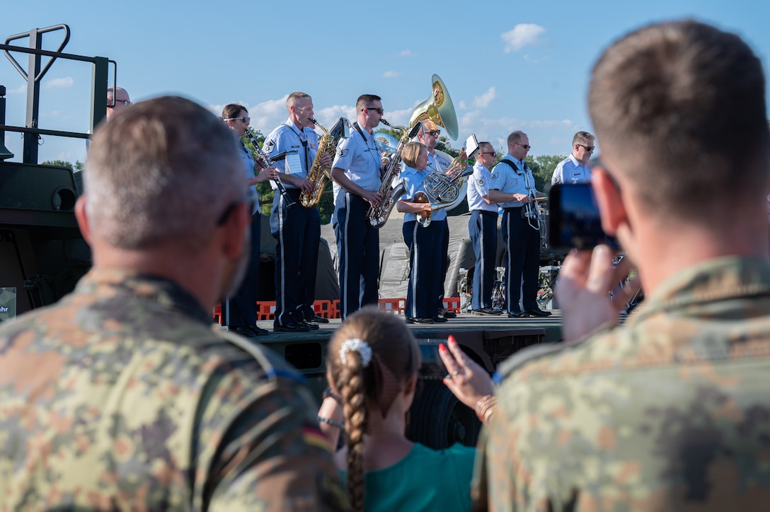 Members of the German armed forces watch the U.S. Air Forces in Europe Ceremonial Band perform during the NATO Days event, at Leoš Janáček Airport in Ostrava, Czech Republic, Sept. 16, 2023. The USAFE Band serves as a bridge to increase cultural ties and enrich the partnerships between the U.S. and Czech Republic through music. (U.S. Air Force photo by Airman 1st Class Christopher Campbell)