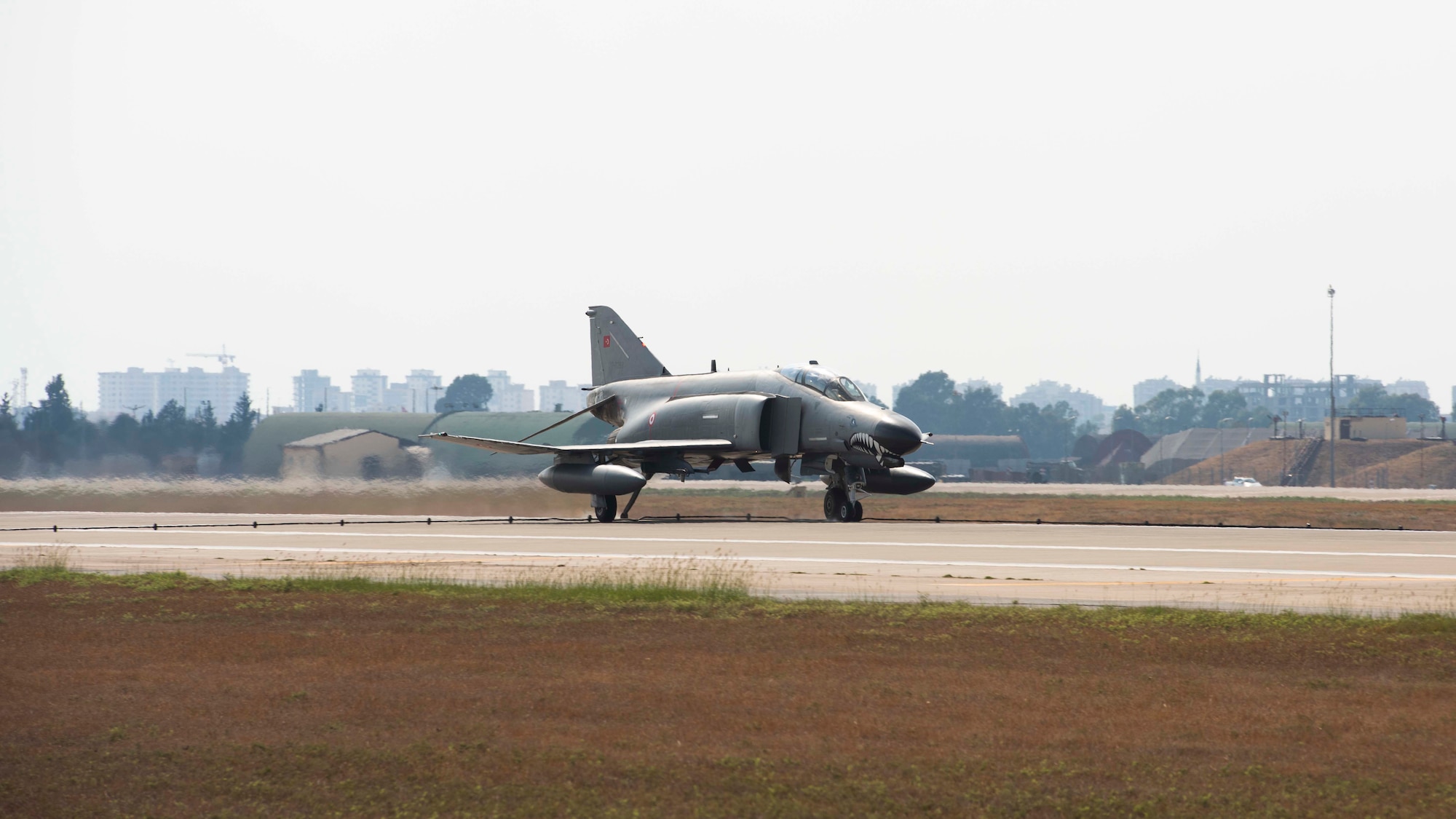 An F-4 fighter jet rolls down a runway