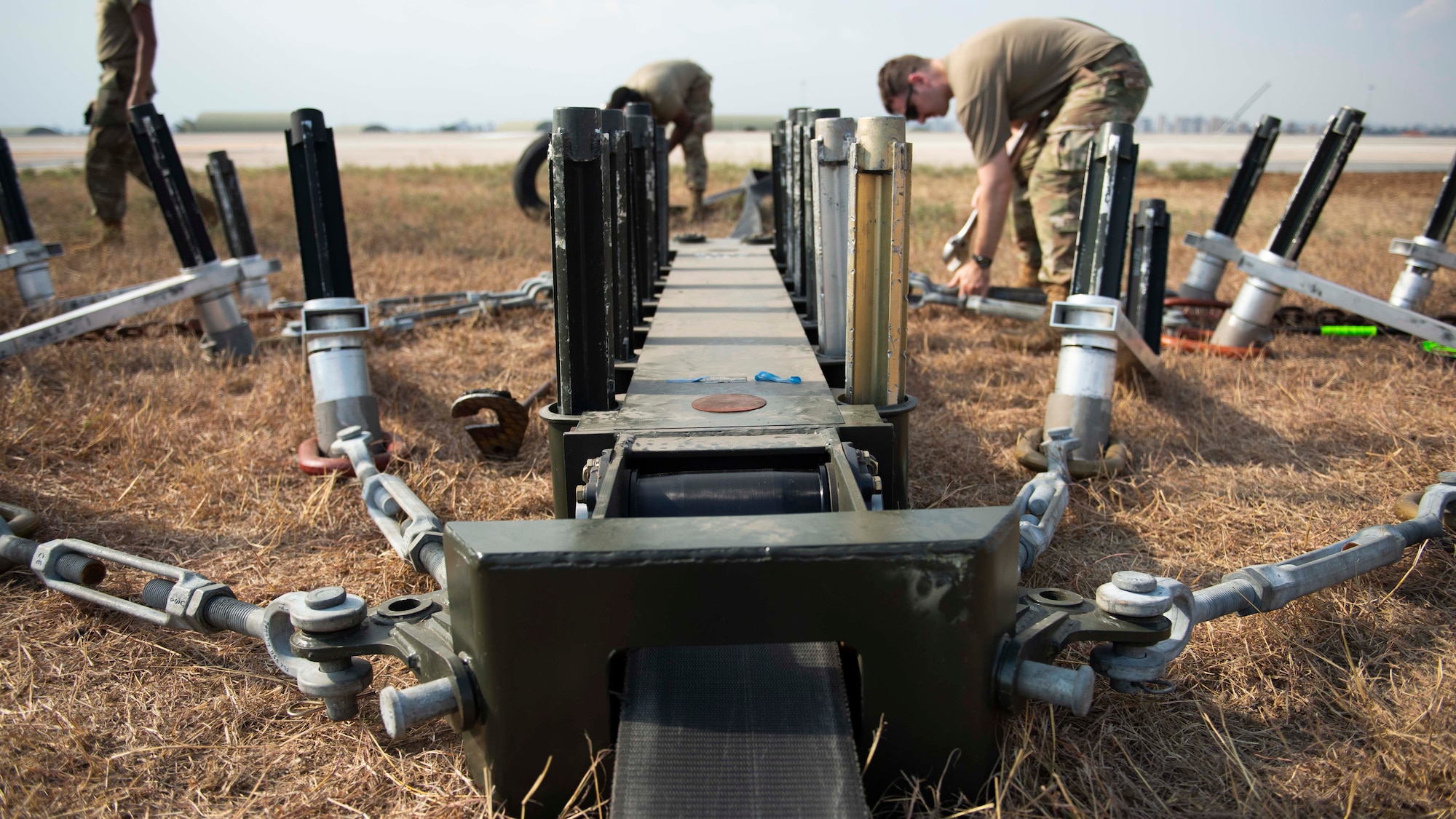 U.S. Airmen install machinery on a runway