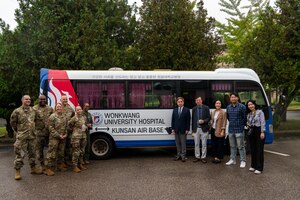 From the left, 8th Medical Group leaders and Wonkwang University Hospital staff, gather in front of the new medical shuttle.