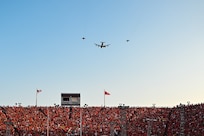 A KC-135R Stratotanker assigned to the 155th Air Refueling Wing flies over Memorial Stadium with F-16 Fighting Falcons assigned to the 114th Fighter Wing during the national anthem for the University of Nebraska volleyball game in Lincoln, Nebraska, Aug. 30, 2023. The event broke the world record for women’s sporting event attendance with 92,003 fans.