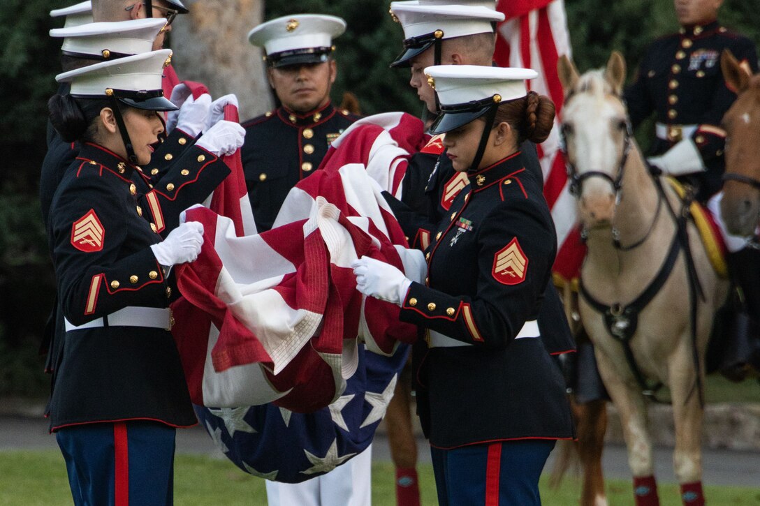 Marines fold the American flag during a formal ceremony.