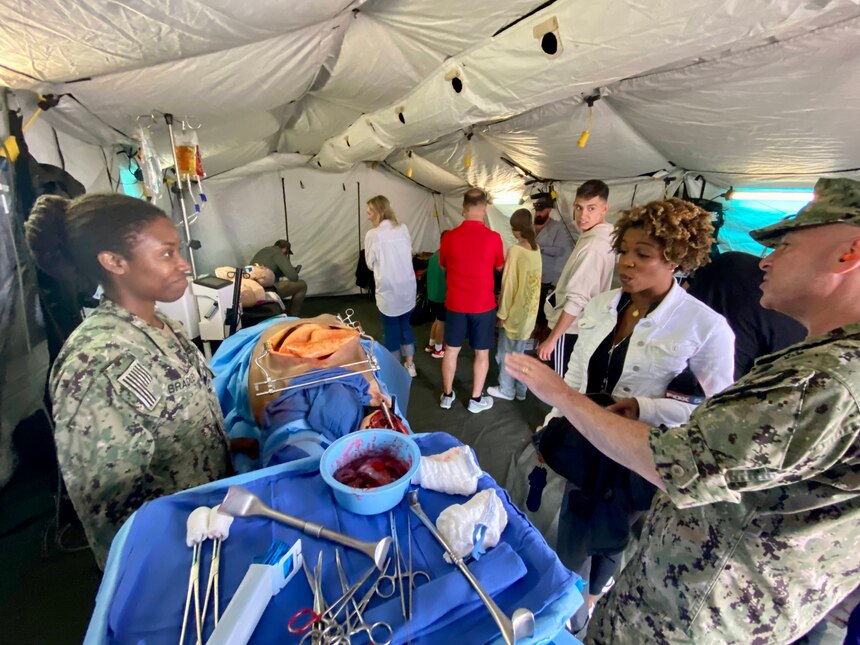 Lt. Tiffany F. Bradley (L), Naval Medical Center San Diego's Staff Education and Training assistant department head and assistant diversity officer, showcases an advanced high-fidelity simulation mannequin at Marine Corps Air Station Miramar's  ‘America's Airshow,’ Sept. 22, 2023.  Navy Medicine's critical capability of expeditionary medicine and its ability to stabilize and save the warfighter was on full display with a mobile medical tent filled with cutting-edge medical simulation equipment during the airshow weekend.  The mission of NMCSD is to prepare service members to deploy in support of operational forces, deliver high quality health care services, and shape the future of military medicine through education, training, and research. NMCSD employs more than 6,000 active-duty military personnel, civilians and contractors in southern California to provide patients with world-class care anytime, anywhere.