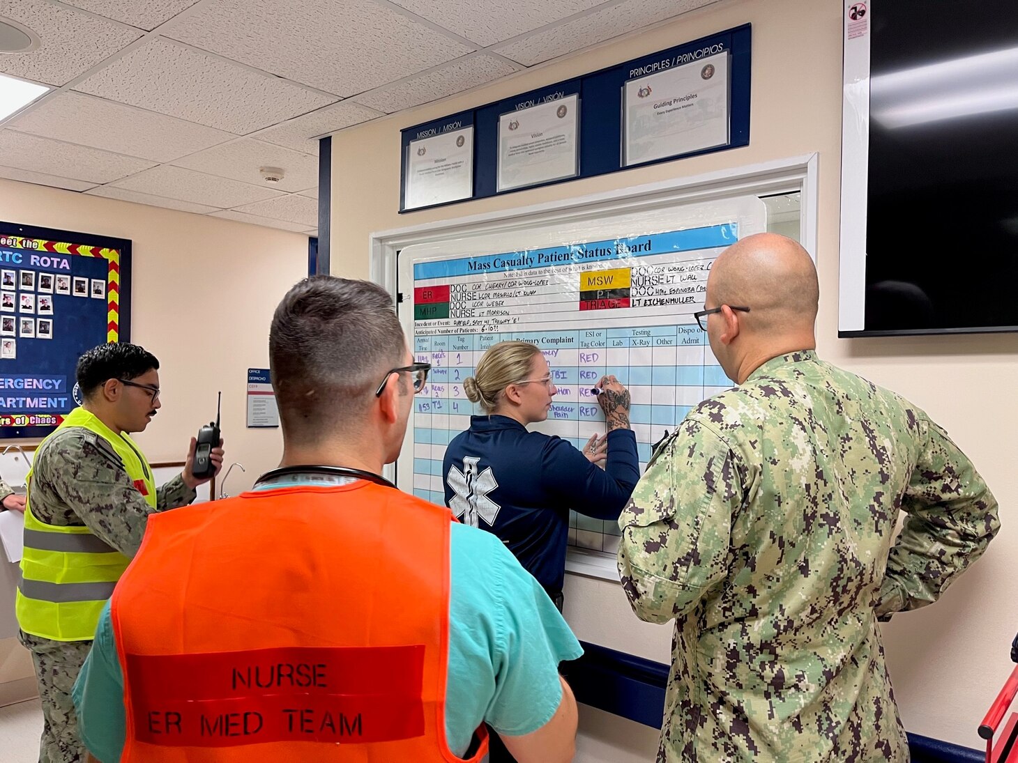 Lieutenant Commander Andrew Masiello (Staten Island, NY) and Hospital Corpsman Third Class Rebekah Chute (Woodlands, TX) update the mass casualty board to ensure the care team stays informed on patient care needs and location, during a mass casualty drill at Navy Medicine Readiness and Training Command on August 22, 2023.  Naval Hospital Rota is a forward deployed ready medical treatment facility protecting force health, sustaining medical readiness, and prepared to surge support for a major logistics base and joint tenants on demand by EUCOM, AFRICOM, and CENTCOM.