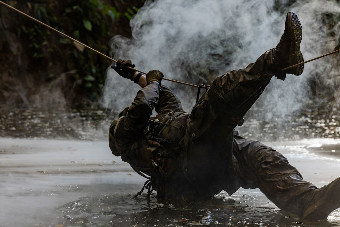 A Marine Raider with Marine Forces Special Operations Command navigates a single rope bridge during a jungle mobility course, Aug. 4, 2023. Marine Raiders in the training program learned to maneuver in a jungle environment, conceal their movements, and track adversary movements. (U.S. Marine Corps photo by Cpl. Henry Rodriguez)