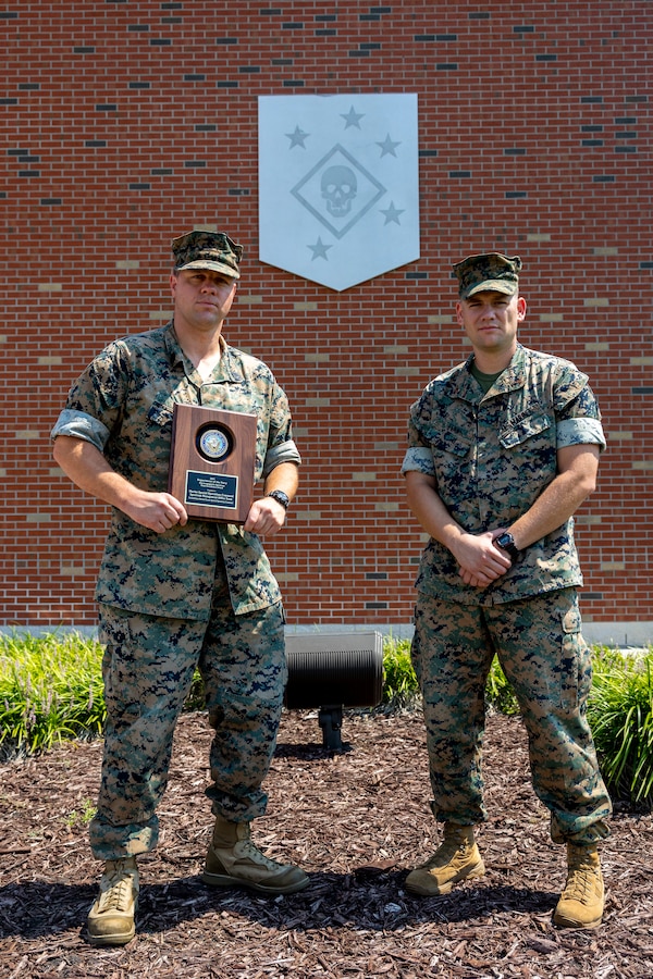 U.S. Marine Corps Gunnery Sgt. Gary Hohn, spectrum manager, Marine Forces Special Operations Command, and Chief Warrant Officer 2 Matthew Evans, electromagnetic spectrum officer, pose for a photo after receiving the annual Navy-Marine Corps Spectrum Excellence Team Award, Camp Lejeune, North Carolina, Aug. 29, 2023. The team was nominated by the Deputy Commandant for Information over all other commands across the Fleet Marine Force for the innovation they are pioneering in electromagnetic communication. (U.S. Marine Corps photo by Sgt. Evan Jones)