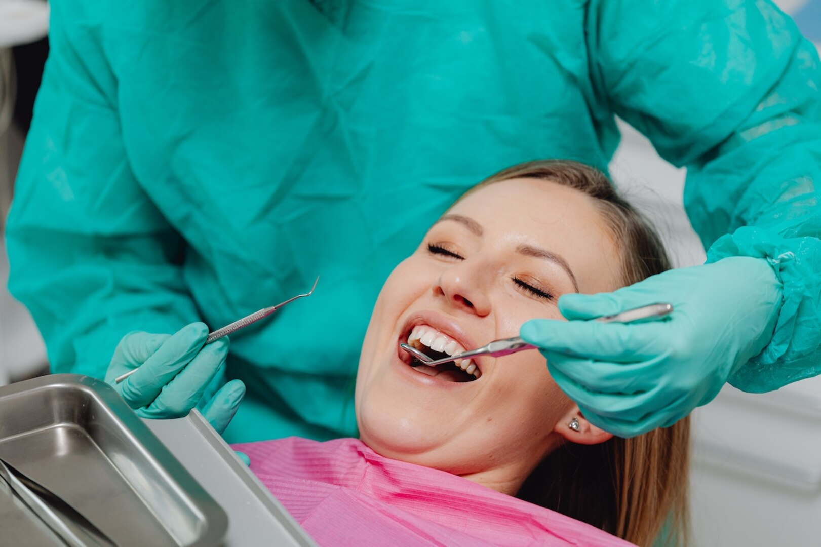 A dentist checks a woman's mouth
