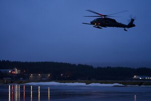 A 210th Rescue Squadron HH-60G Pave Hawk combat search and rescue helicopter carrying U.S. Coast Guardsmen of the Maritime Security Response Team conducts joint hoist training Jan. 23, 2023, at Coast Guard Station Kodiak.
