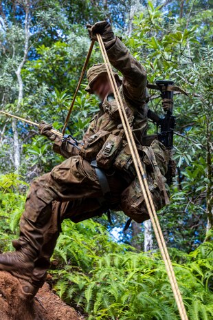 A Marine Raider with Marine Forces Special Operations Command rappels down a cliff face during a jungle mobility course