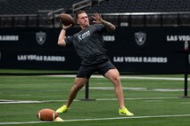 U.S. Air Force Staff Sgt. Taylor Thagard, 99th Civil Engineer Squadron fire and emergency services NCO in charge of training, throws a football during the United Services Automobile Association Salute to Service Bootcamp at Allegiant Stadium, Las Vegas, Nevada, Sept. 19, 2023.