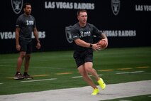 U.S. Air Force Staff Sgt. Taylor Thagard, 99th Civil Engineer Squadron fire and emergency services NCO in charge of training, runs football drills during the United Services Automobile Association Salute to Service Bootcamp at Allegiant Stadium, Las Vegas, Nevada, Sept. 19, 2023.