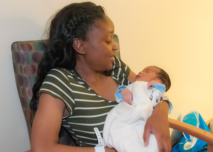 A woman holds a small baby.