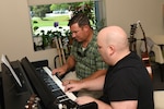 Marine Corps Gunnery Sergeant Paul "Buck" Chambers (left) works with Intrepid Spirit's Music Therapist Clayton Cooke during a music therapy session.