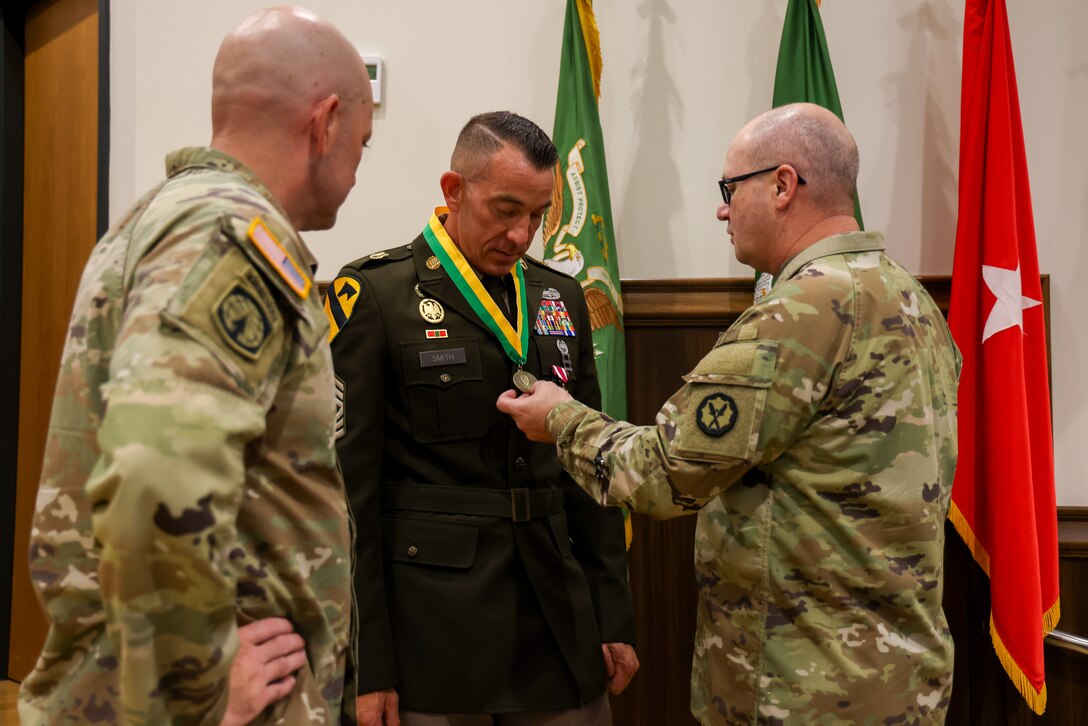An Army Soldier is awarded a medal by another Soldier.