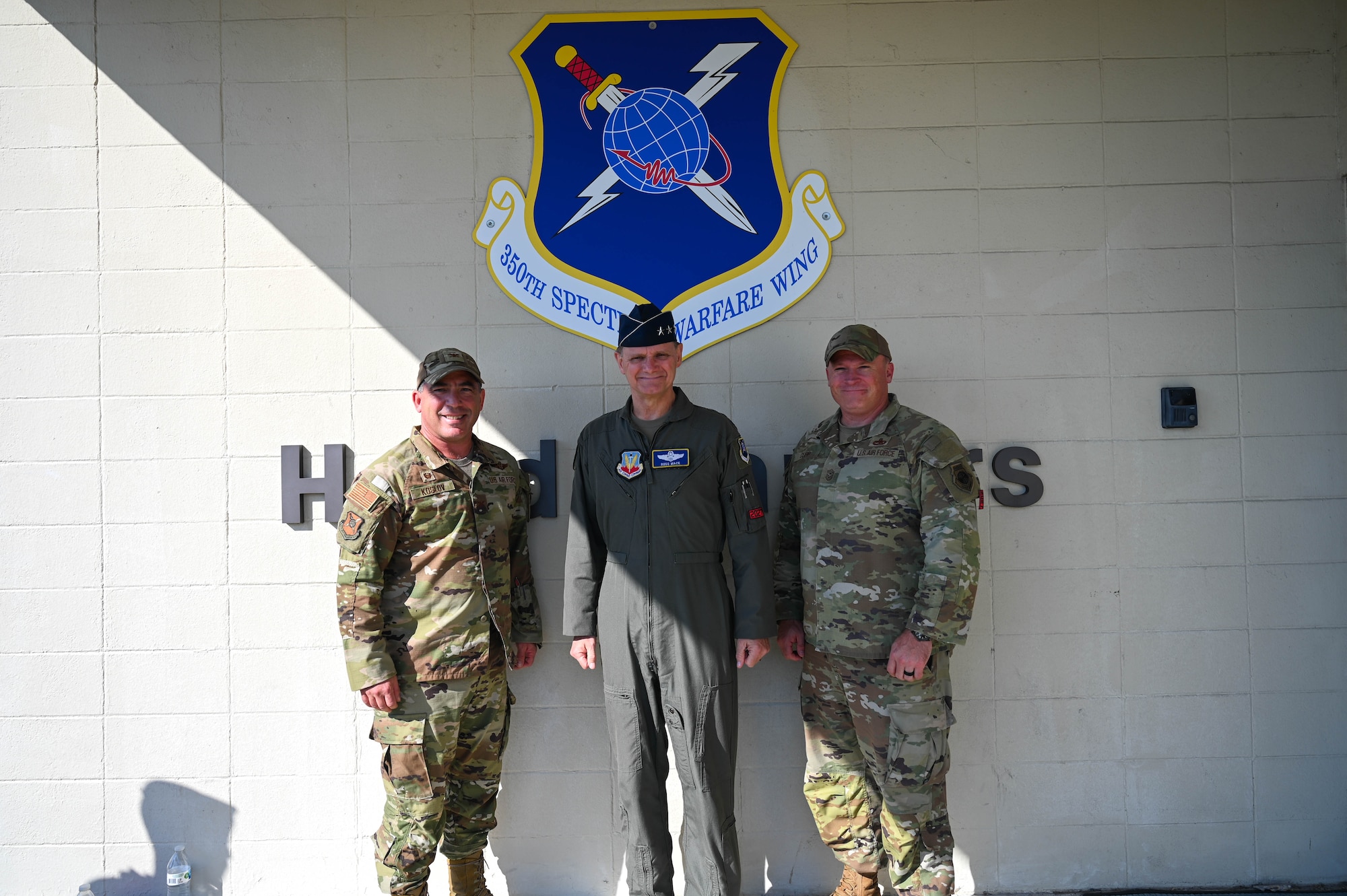 U.S. Air Force Lt. Gen. Russ Mack, deputy commander of Air Combat Command, center, Josh Koslov, 350th Spectrum Warfare Wing commander, left, and Chief Master Sgt. William Cupp, 350th SWW command chief, right, pose for a photo following a wing visit at Eglin Air Force Base, Fla., Sept. 6, 2023. The  mission of the 350th SWW is to deliver adaptive and cutting-edge electromagnetic spectrum capabilities that provide the warfighter a tactical and strategic competitive advantage and freedom to attack, maneuver, and defend. (U.S. Air Force photo by Capt. Benjamin Aronson)