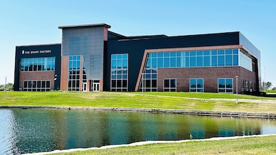 A building sits behind a small pond.