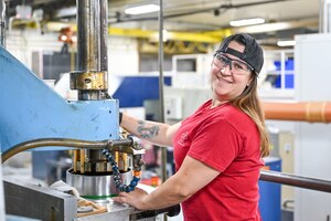 Jessica Soltero, 532nd Commodities Maintenance Squadron, stands next to Hill Air Force Base's vertical hone machine, which is used to sand, hone and polish the inside of the pistons cylinder walls on a C-5 Galaxy aircraft. (U.S. Air Force photo by Cynthia Griggs)