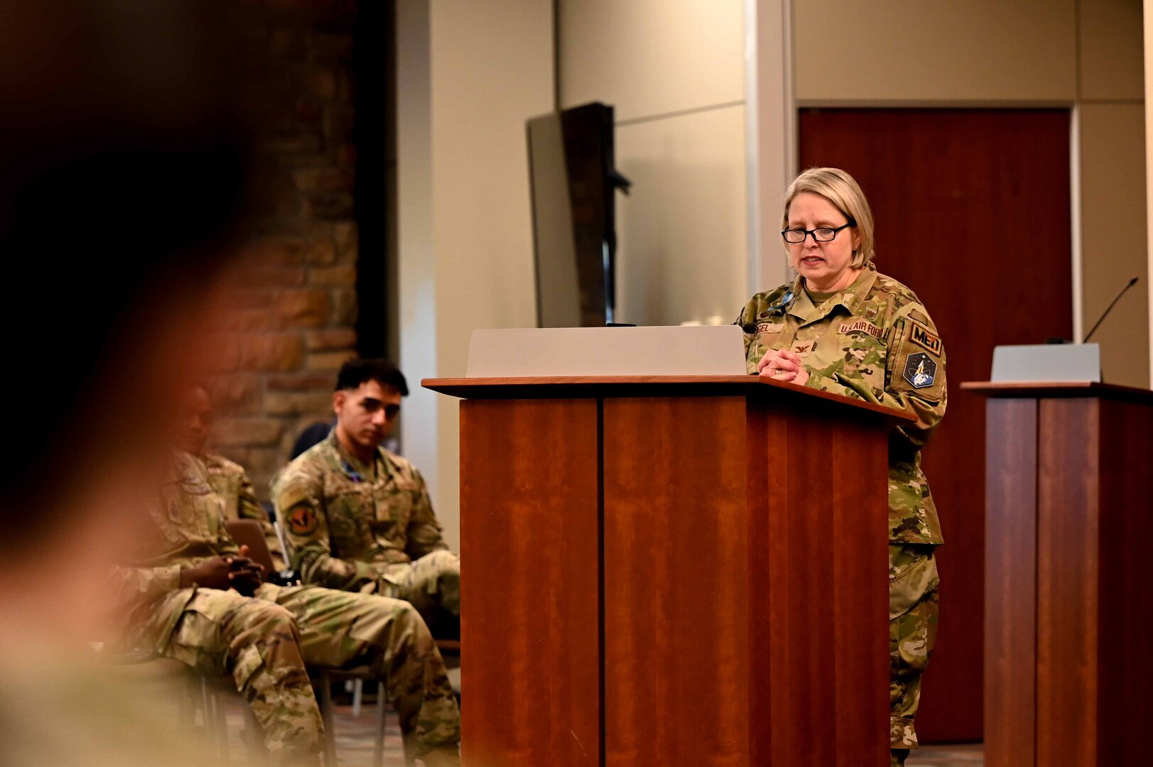 Woman stands at podium and speaks to audience