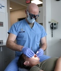 Air Force Periodontist examines mouth