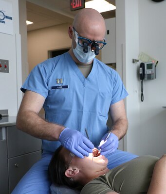 Air Force Periodontist examines mouth