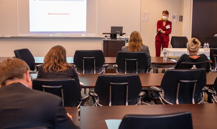 A woman stands at the front of a classroom.