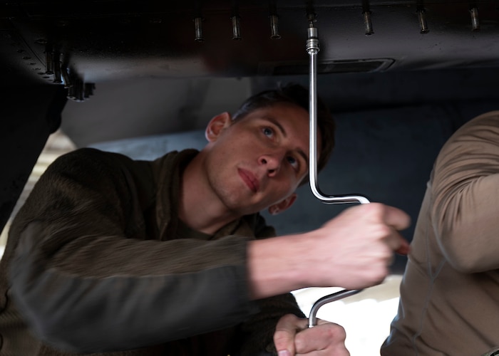 A maintainer works on an aircraft