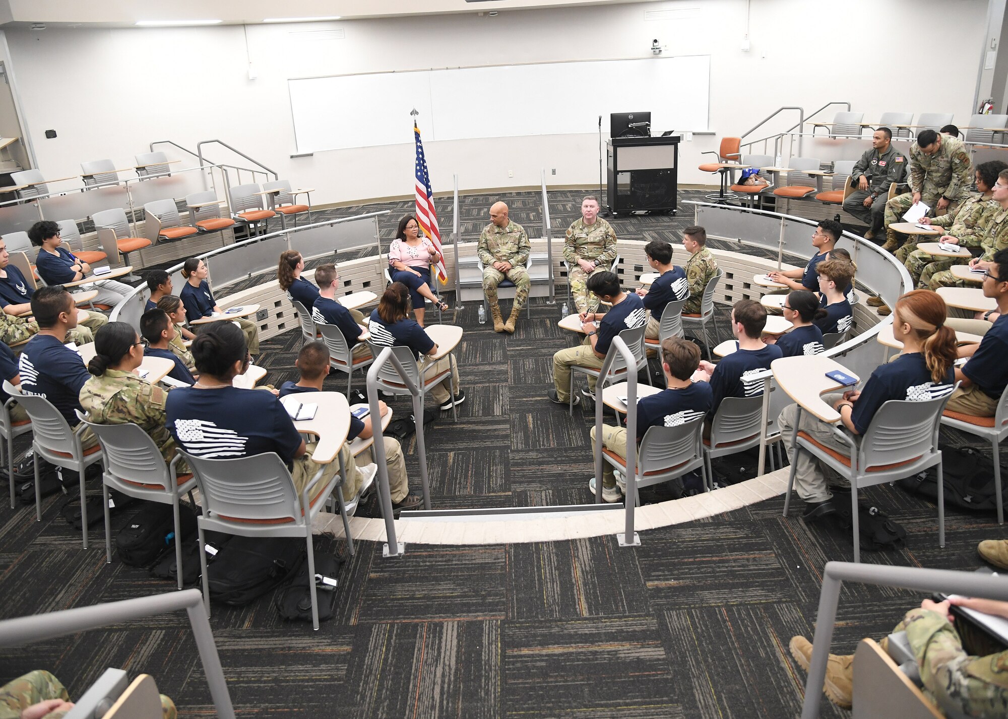 Man has a discussion with a crowd of students.