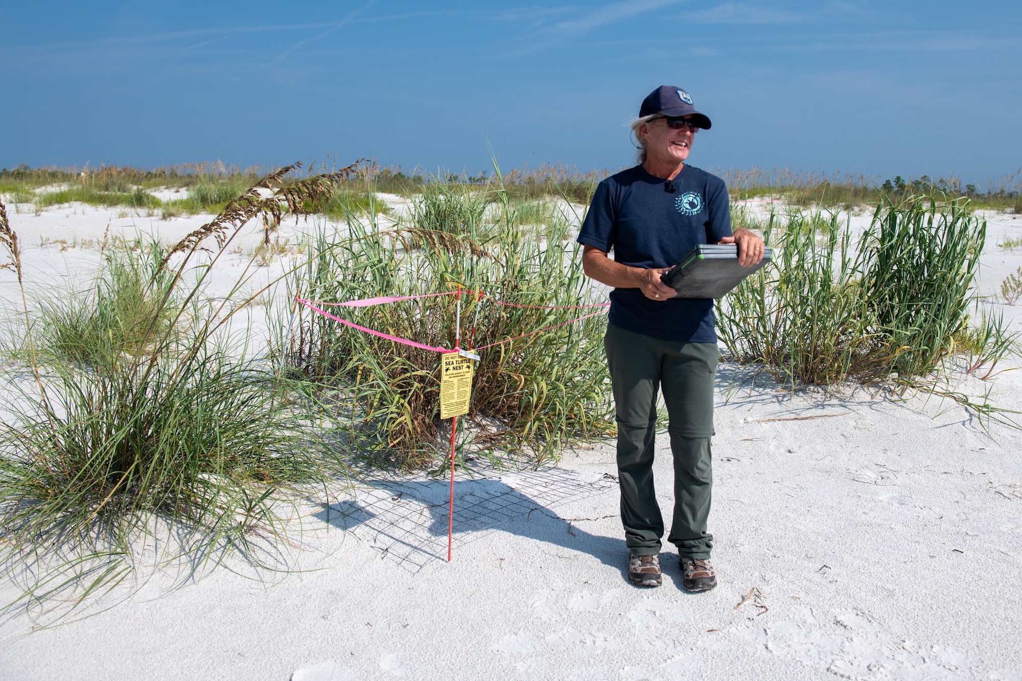 Woman stands by sea turtle nest.