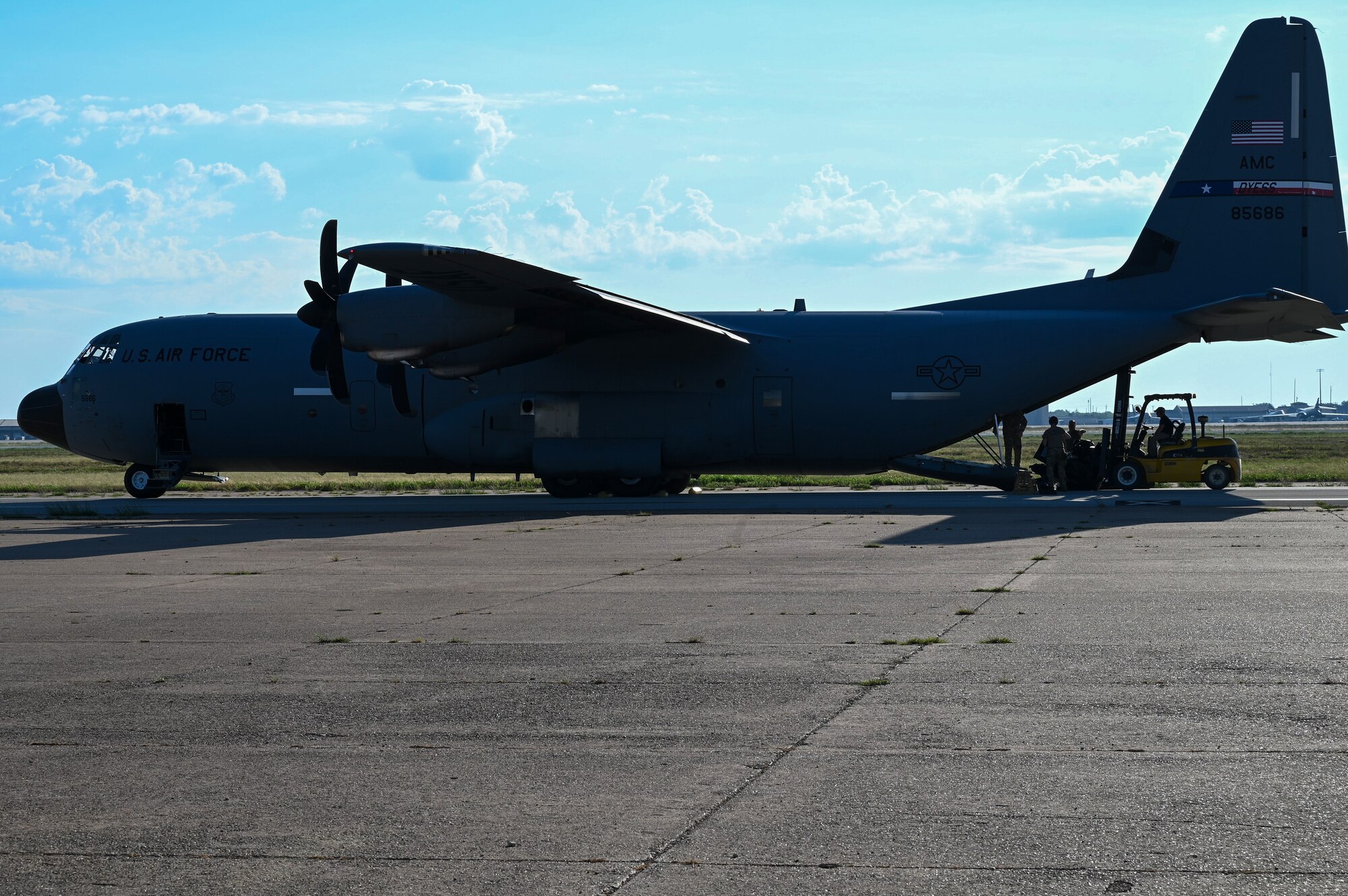 A C-130J Super Hercules parks on the runway as tent kits are unloaded at Dyess Air Force Base, Texas, Sept. 19, 2023. The demonstration showcased the mobility of a Tactical Operating Center in a single cargo box that could be brought to deployed environments as needed. (U.S. Air Force photo by Senior Airman Sophia Robello)