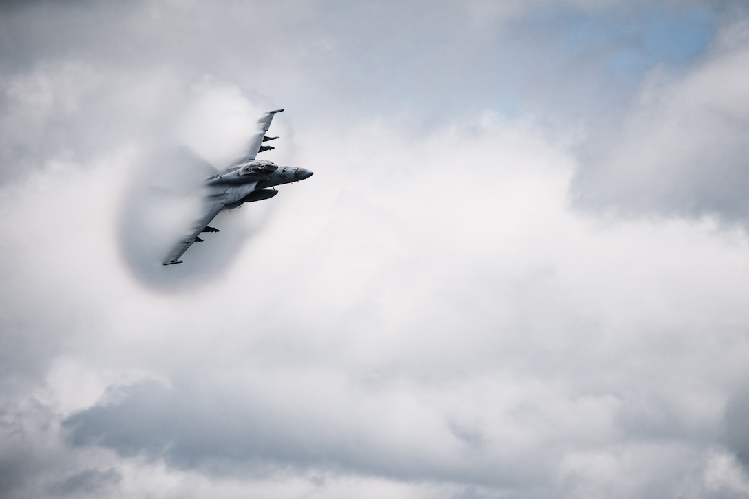 A fighter jet flies through clouds.