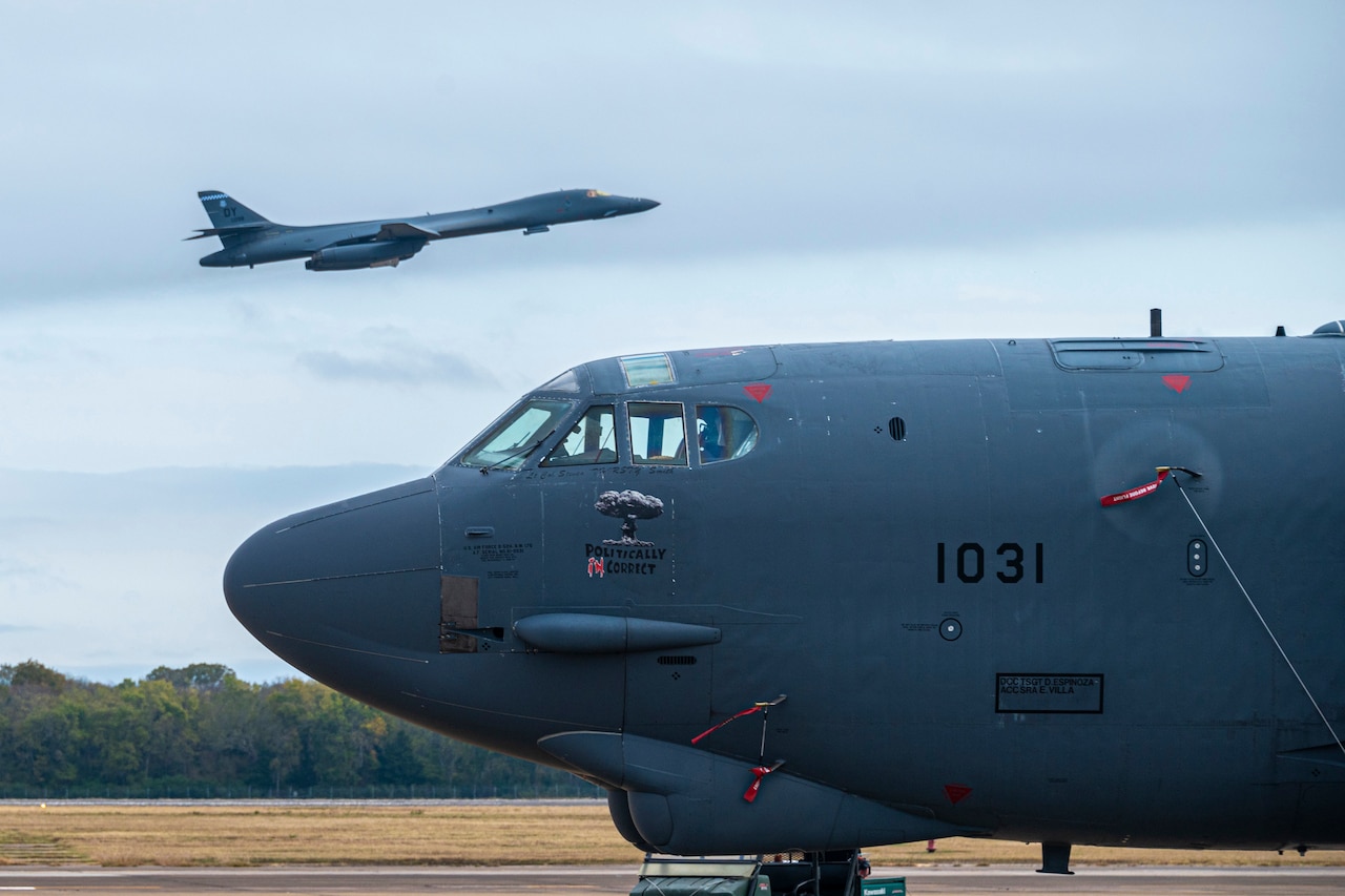 An airplane flies above an airplane on a runway.