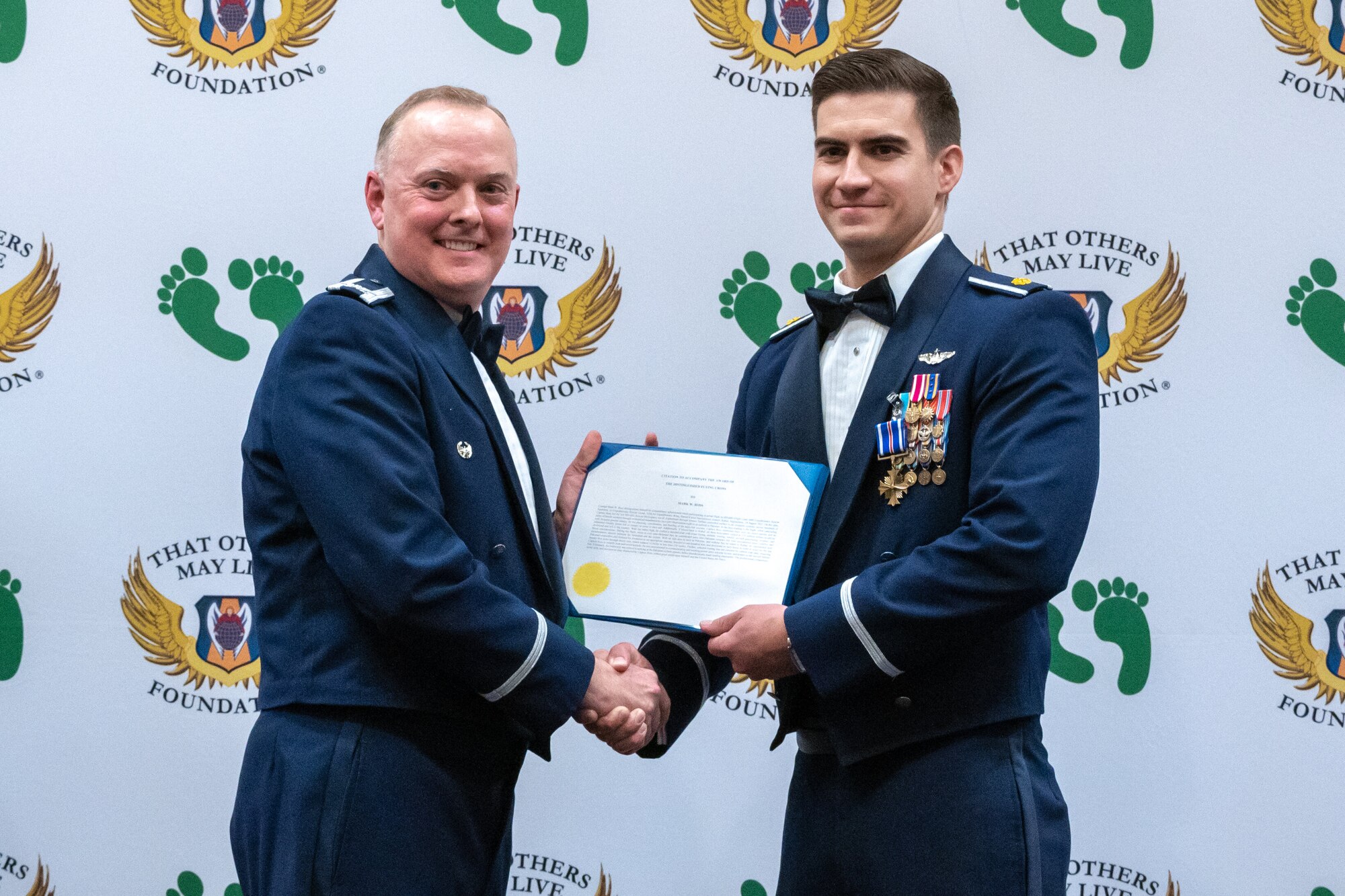 U.S. Air Force Maj. Mark Ross, 66th Rescue Squadron HH-60G Evaluator helicopter pilot, left, was awarded the Distinguished Flying Cross at Nellis Air Force Base, Nev., Sept. 23, 2023. Ross was awarded the DFC because of his heroism and extraordinary actions in aerial flight during is deployment to Kabul, Afghanistan; He led the last U.S. Air Force HH-60G helicopters out of Afghanistan, through known Taliban controlled surface to air weapon systems, on August 29, 2021. (U.S. Air Force photo by Airman 1st Class Elizabeth Tan)