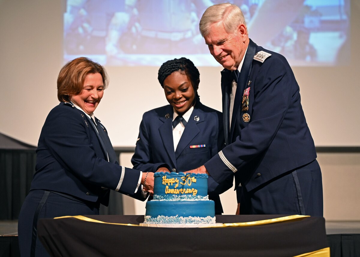 U.S. Air Force Col. Angelina Maguinness, left, 17th Training Wing commander, Airman Jenelle Daily, middle; 17th Healthcare Operations Squadron family health medical technician; and retired Lt. Gen. Joseph Wehrle, right, first 17th TRW commander, cut the cake during the Air Force Ball at the McNease Convention Center, San Angelo, Texas, Sept. 23, 2023. The youngest and oldest Airman cut the cake together symbolizing the heritage passed down between generations. (U.S. Air Force photo by Senior Airman Sarah Williams)