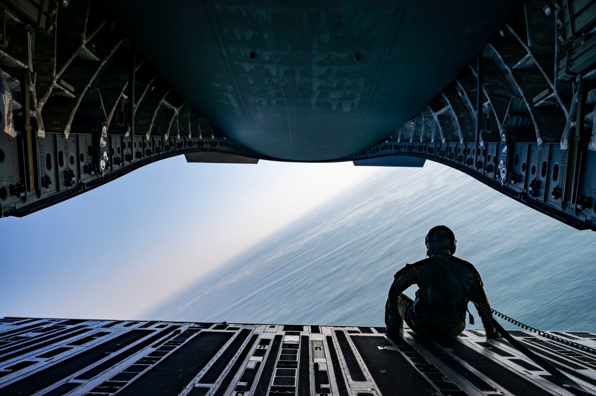 U.S. Air Force Tech. Sgt. Cody Deranick, 3rd Airlift Squadron loadmaster, searches for a life raft from the back of a U.S. Air Force C-17 Globemaster III during Exercise Castaway 23-3 near Indian River Inlet, Delaware, Sept. 6, 2023. Castaway 23-3 was a Total Force, Interagency training exercise designed to train and update local search and rescue procedures. (U.S. Air Force photo by Airman 1st Class Amanda Jett)