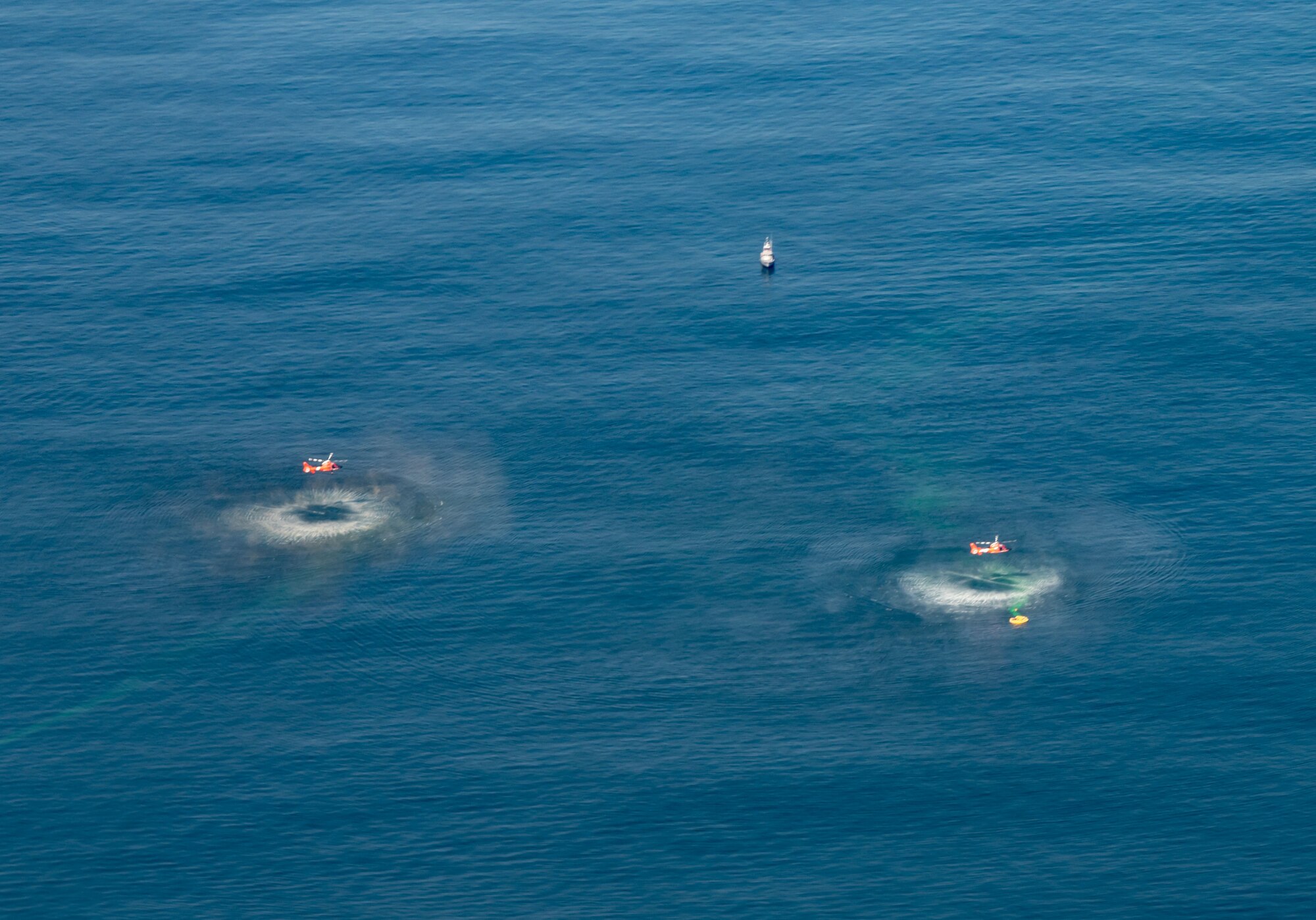 Two MH-65 Dolphin helicopters from U.S. Coast Guard Air Station Atlantic City, New Jersey, conduct rescue operations during Exercise Castaway 23-3 near Indian River Inlet, Delaware, Sept. 6, 2023. Castaway 23-3 was a Total Force, Interagency training exercise designed to train and update local search and rescue procedures. (U.S. Air Force photo by Airman 1st Class Amanda Jett)