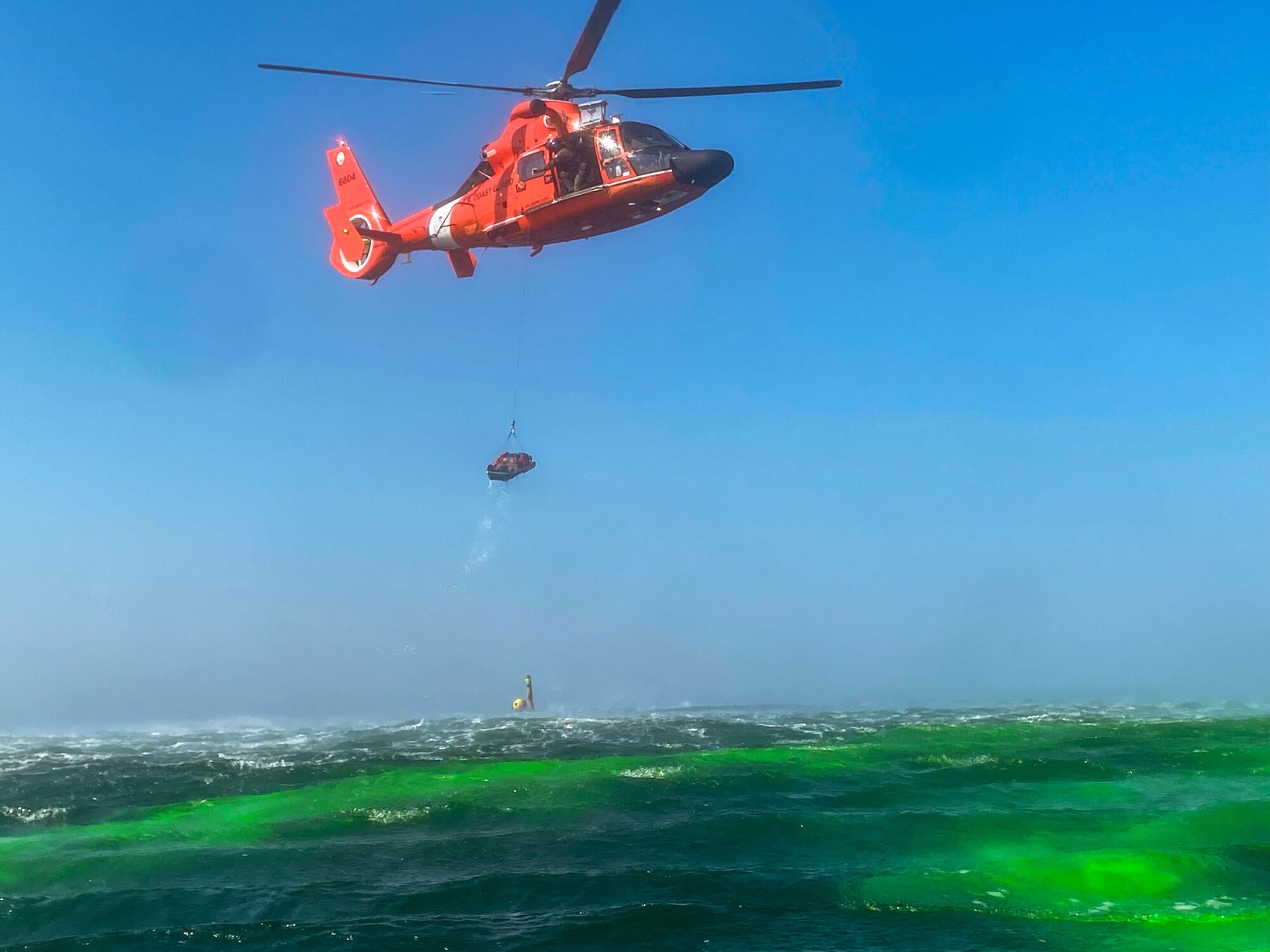 An Exercise Castaway 23-3 participant is hoisted onto a MH-65 Dolphin helicopter from U.S. Coast Guard Air Station Atlantic City, New Jersey, near Indian River Inlet, Delaware, Sept. 6, 2023. Castaway 23-3 was a Total Force, Interagency training exercise designed to train and update local search and rescue procedures. (U.S. Air Force photo by Airman 1st Class Dieondiere Jefferies)