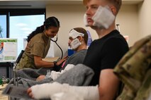 An Airman from the 341st Medical Group checks a simulated casualty’s heartbeat during Ready EAGLE II, a training exercise held biennially at Malmstrom Air Force Base, Mont., Sept. 21, 2023. Roughly 60 patient actors volunteered for this training, allowing the medics to train on real people. (U.S. Air Force photo by Senior Airman Breanna Christopher Volkmar)