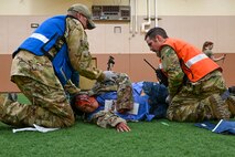 Two Airmen from the 341st Medical Group flip a simulated casualty onto a gurney during Ready EAGLE II at Malmstrom Air Force Base, Mont., Sept. 21, 2023. Ready EAGLE II is a medical readiness contract providing training and exercise for the squadron on a biennial basis. (U.S. Air Force photo by Senior Airman Breanna Christopher Volkmar)