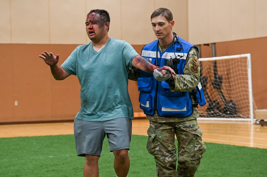 An Airman from the 341st Medical Group guides a simulated casualty toward triage during Ready EAGLE II, a training exercise held biennially at Malmstrom Air Force Base, Mont., Sept. 21, 2023. Over 100 medics were trained during this exercise, practicing their triage, decontamination, treatment and patient tracking skills on roughly 60 volunteer actors. (U.S. Air Force photo by Senior Airman Breanna Christopher Volkmar)