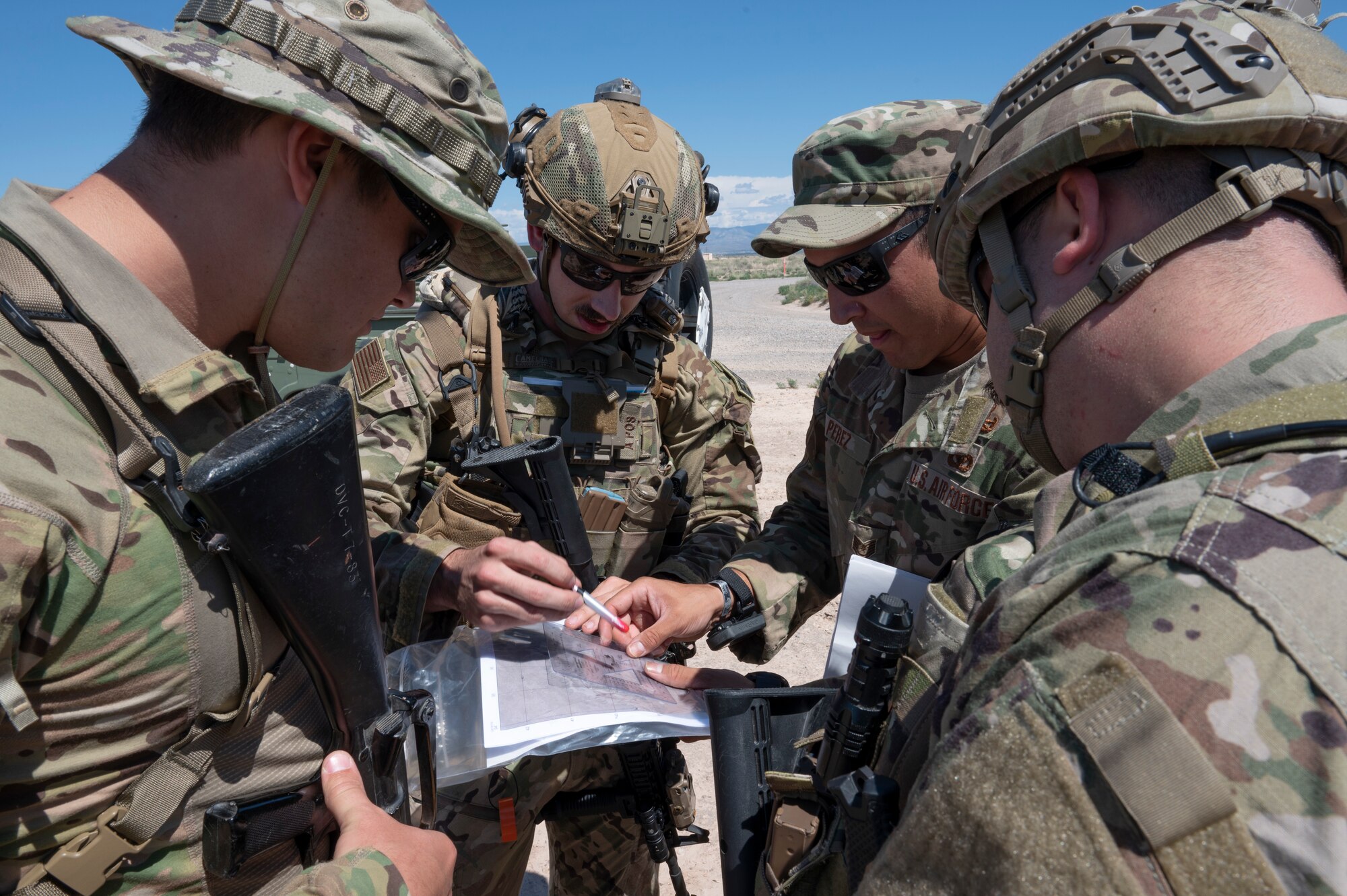 Airmen from the 49th Civil Engineer Squadron explosive ordnance disposal flight review map coordinates during a land navigation exercise at Holloman Air Force Base, New Mexico, Sep. 18, 2023. The EOD flight applies special techniques and procedures to lessen or remove the hazards created by the presence of unexploded ordnance. (U.S. Air Force photo by Airman 1st Class Michelle Ferrari)