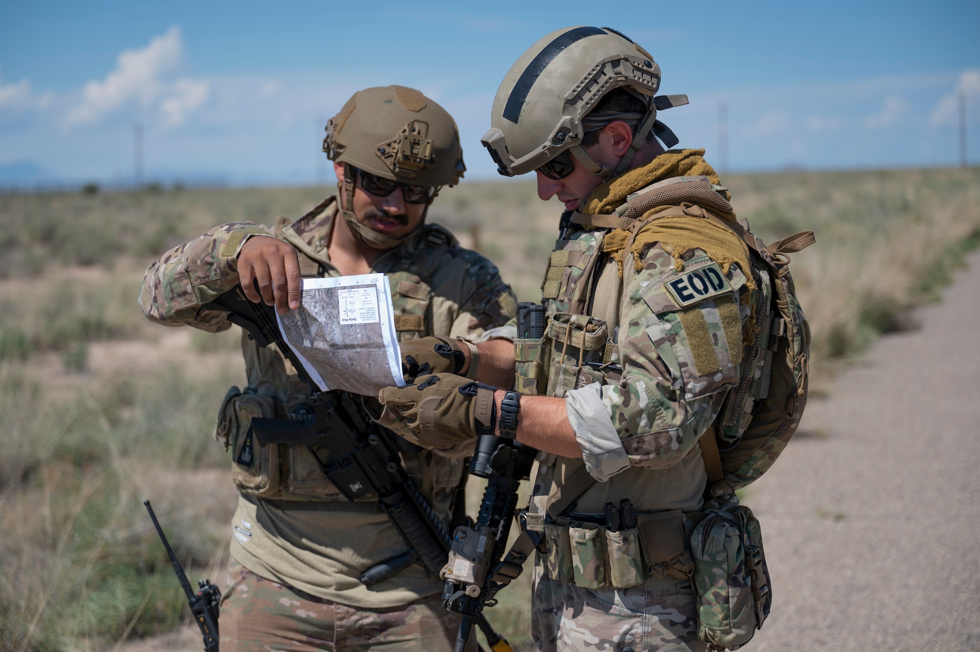 U.S. Air Force Tech. Sgt. Nathan Hollibaugh, left, 49th Civil Engineer Squadron explosive ordnance disposal NCO of quality assurance, and U.S. Air Force Senior Airman Patrick Conte, 49th CES EOD training manager, review coordinates on a map during a land navigation exercise at Holloman Air Force Base, New Mexico, Sep. 18, 2023. The EOD flight applies special techniques and procedures to lessen or remove the hazards created by the presence of unexploded ordnance. (U.S. Air Force photo by Airman 1st Class Michelle Ferrari)