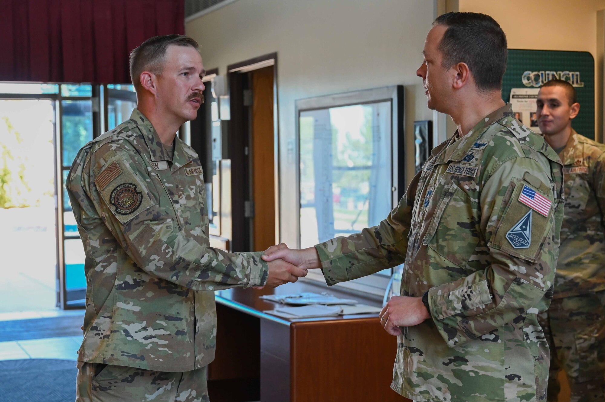 CMSgt Lloyd shakes hands with TSgt. Braaten