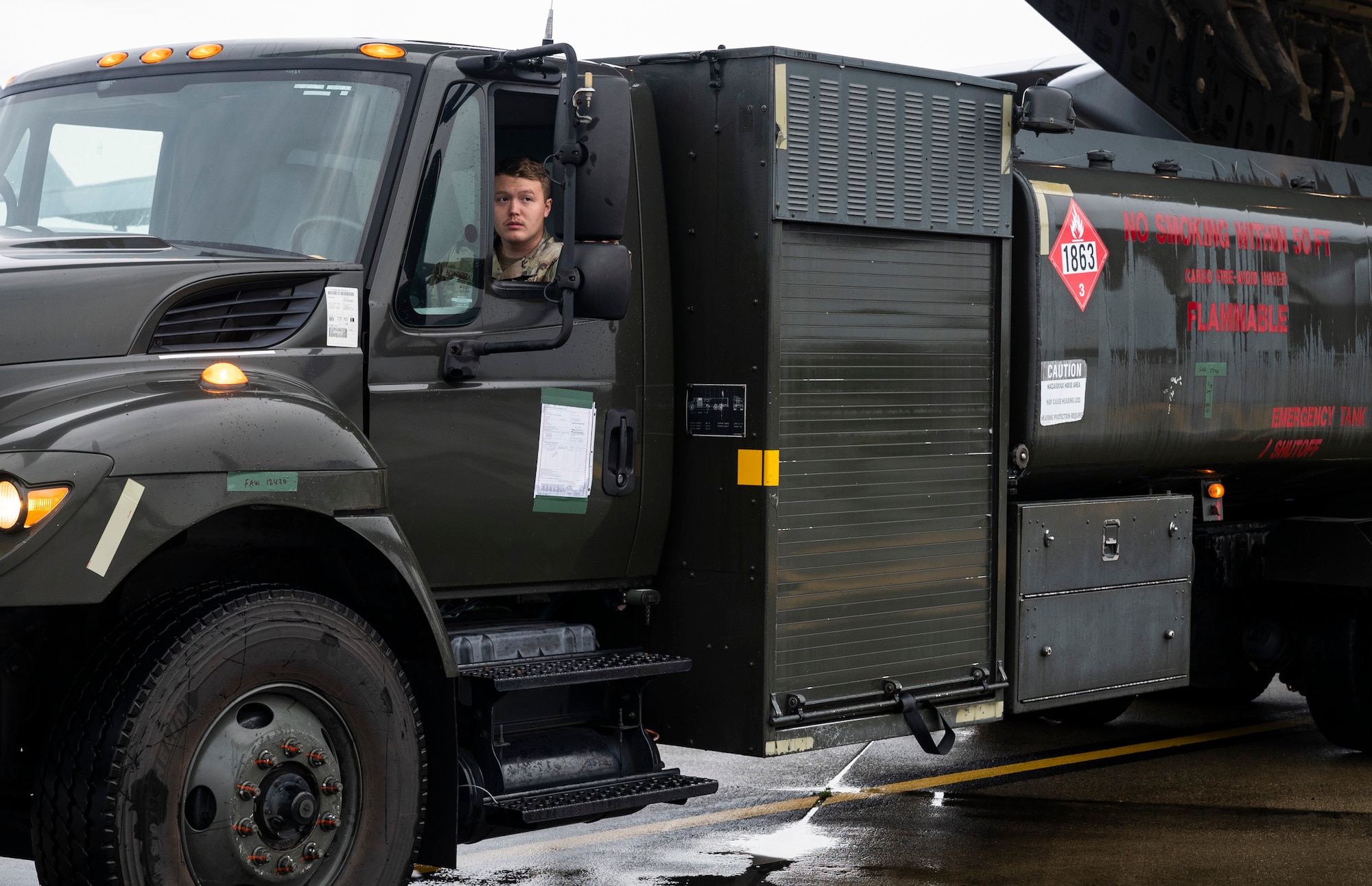 U.S. Air Force Senior Airman Joseph Nowosielski, a fuels apprentice with the 627th Logistics Readiness Squadron, checks the mirrors while driving an R-11 fuel truck onto a C-17 Globemaster III during Exercise Rainier War 23A at Joint Base Lewis-McChord, Washington, Sept. 25, 2023. Rainier War is an annual exercise led by the 62d Airlift Wing designed to evaluate the ability to generate, employ and sustain in-garrison and forward deployed forces. These exercises are necessary in assessing and maintaining wartime operational tempos, ensuring command and control across multiple locations. During the exercise, Airmen will respond to scenarios that replicate today’s contingency operations and will address full-spectrum readiness against modern threats brought on by peer adversaries. (U.S. Air Force photo by Staff Sgt. Rachel Williams)