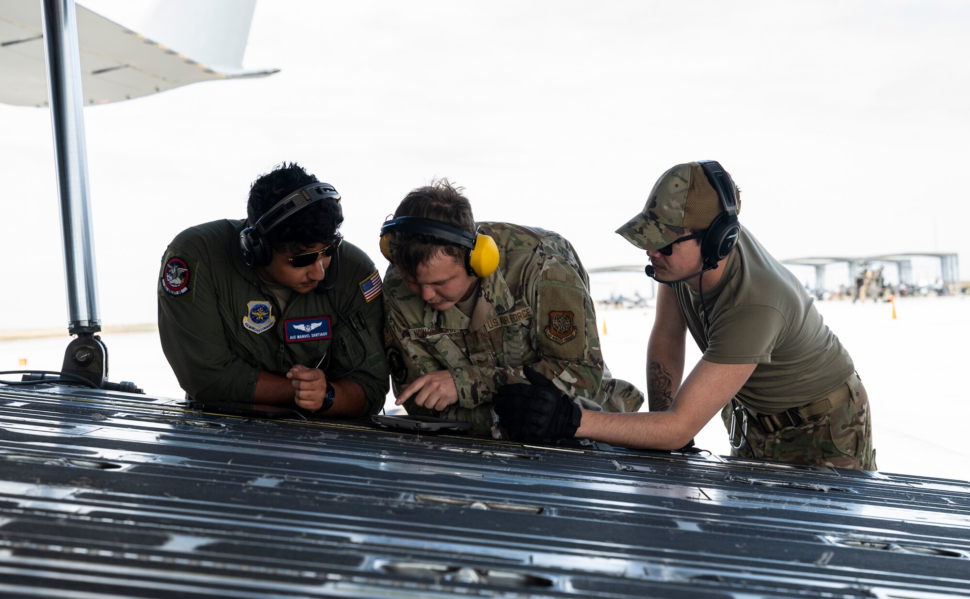 U.S. Air Force Airman 1st Class Manuel Santiago, left, a loadmaster with the 4th Airlift Squadron, Senior Airman Joseph Nowosielski, center, a fuels apprentice with the 627th Logistics Readiness Squadron, and Senior Airman Kainoa Cook, a loadmaster with the 4th AS, review a checklist while performing specialized fueling operations during Exercise Rainier War 23A at Mountain Home Air Force Base, Idaho, Sept. 25, 2023. Rainier War is an annual exercise led by the 62d Airlift Wing designed to evaluate the ability to generate, employ and sustain in-garrison and forward deployed forces. These exercises are necessary in assessing and maintaining wartime operational tempos, ensuring command and control across multiple locations. During the exercise, Airmen will respond to scenarios that replicate today’s contingency operations and will address full-spectrum readiness against modern threats brought on by peer adversaries. (U.S. Air Force photo by Staff Sgt. Rachel Williams)