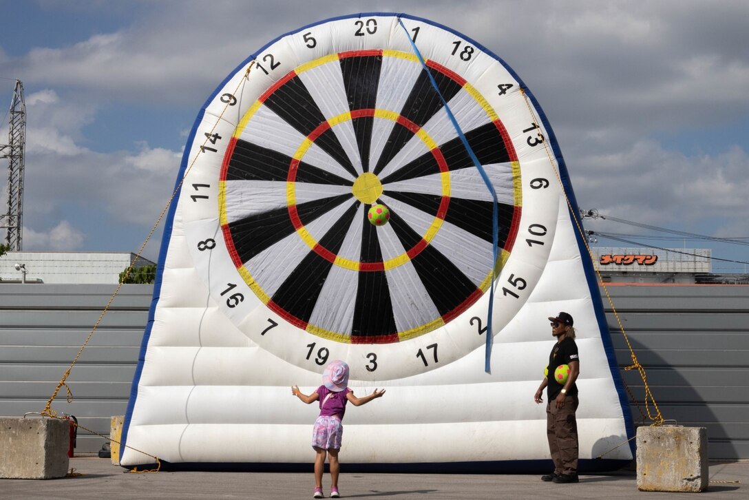 A child plays a carnival-style game during the Camp Kinser Festival on Camp Kinser, Okinawa, Japan, Sept. 9, 2023. Local community residents and Status of Forces Agreement members were welcomed on base to attend the event hosted by Marine Corps Community Services Okinawa to see a variety of attractions. Musical performances, food trucks, and attractions brought from different areas of Okinawa were available for all attendees. (U.S. Marine Corps photo by Cpl. Zachary Sarvey)