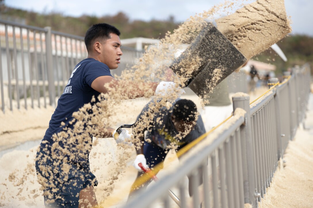 U.S. Marines shovel sand on Kin Sunrise Beach, Okinawa, Japan, Aug. 17, 2023. Marines across several units aboard Okinawa assisted with typhoon recovery efforts on Kin Sunrise Beach, which was flooded with sand and debris. Typhoon Khanun moved through Okinawa as a category 4 storm, bringing strong winds, heavy rain and high seas, marking one of the strongest storms to affect the island in recent years. (U.S. Marine Corps photo by Cpl. Alex Fairchild)